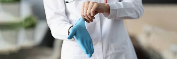 Доктор кладе захисну рукавичку на руку
 - Фото, зображення