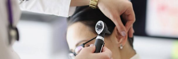 Doctor examines patient ear with otoscope closeup - Photo, Image