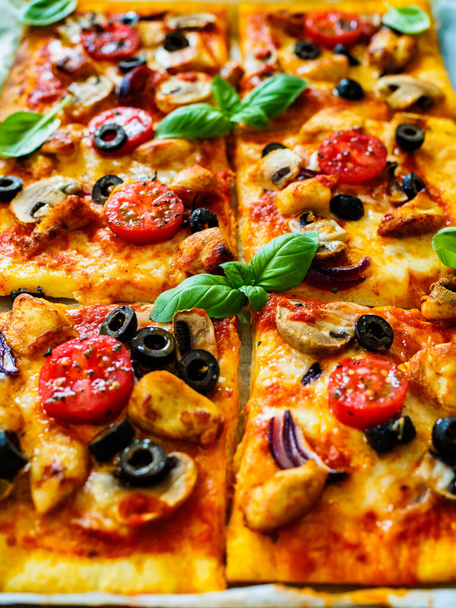 Pizza with white mushrooms, chicken nuggets, tomatoes, black olives and mozzarella on wooden background  - Foto, Imagen