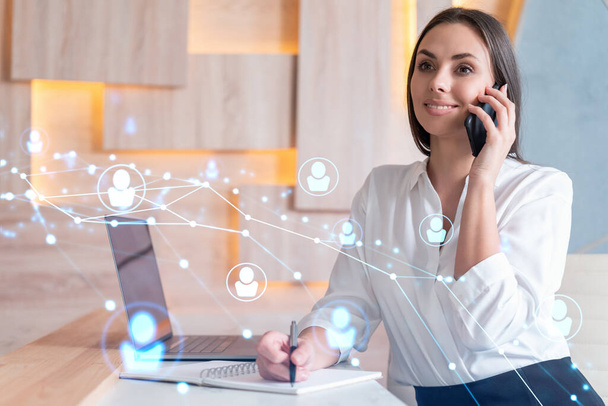 Attractive businesswoman in white shirt has conference call to hire new employees for international business consulting. HR, social media hologram icons over office background - Photo, image