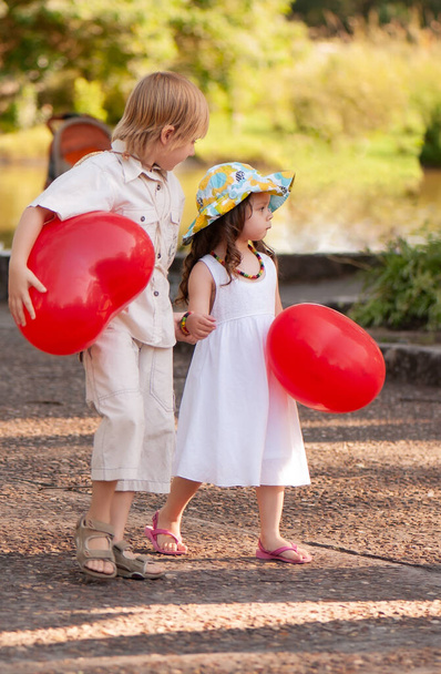 Little girl and boy with balloons in the park - Photo, image