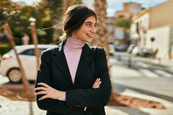 Young beautiful businesswoman smiling happy with arms crossed at the city. - Foto, Imagem