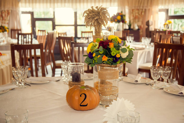 Floricultura festiva em estilo de outono com numeração de mesas em abóboras em salão de banquete. Floricultura e decoração de eventos arranjos florais. - Foto, Imagem