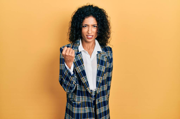 Young latin girl wearing business clothes angry and mad raising fist frustrated and furious while shouting with anger. rage and aggressive concept.  - Photo, Image