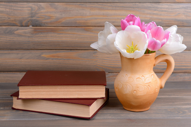 Beautiful tulips in bucket in pitcher on table on grey background - Fotografie, Obrázek