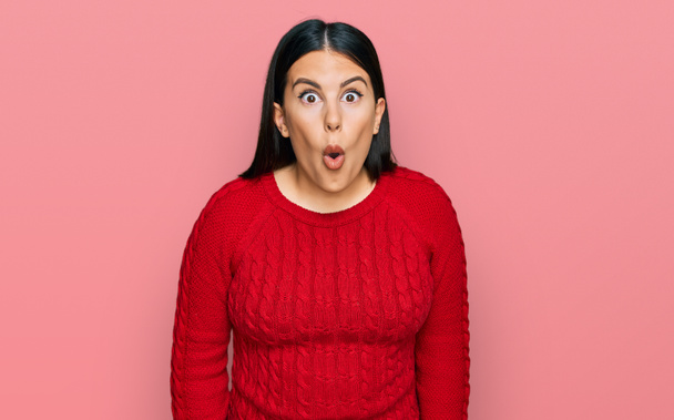 Schöne brünette Frau trägt lässigen Pullover verängstigt und erstaunt mit offenem Mund für Überraschung, ungläubiges Gesicht  - Foto, Bild