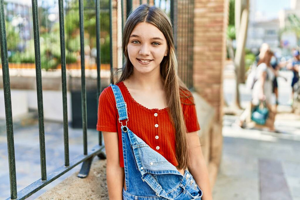 Καυκάσιος έφηβος κορίτσι χαμογελά χαρούμενος στέκεται στην πόλη. - Φωτογραφία, εικόνα