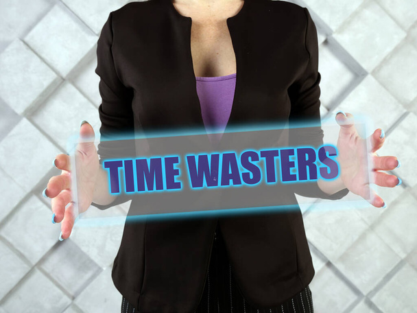  TIME WASTERS szöveg futurisztikus képernyőn. Egy személy, aki tudatosan vagy öntudatlanul megpróbál rávenni, hogy hiábavaló befektetésbe kezdj az energiáddal. - Fotó, kép