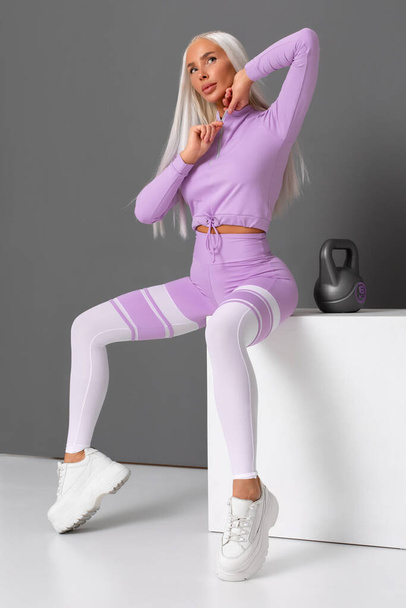 Belle femme de fitness en leggings. Fille athlétique sur le fond gris - Photo, image