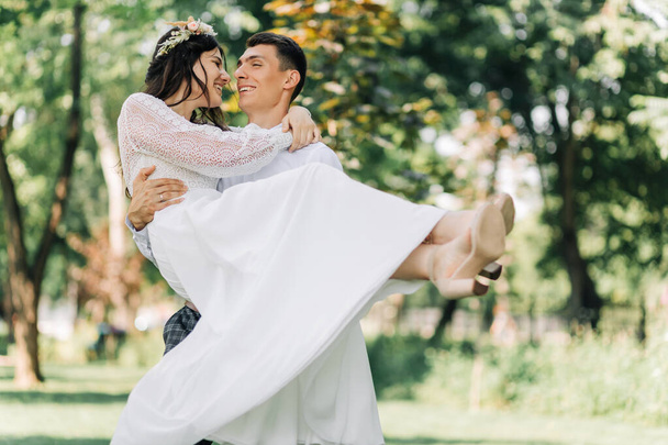 Happy family of bride and groom, Smiling newlyweds together in wedding suits, in the park on a sunny day, Concept of love and happiness, wedding day, wedding ceremony in boho style - Fotografie, Obrázek