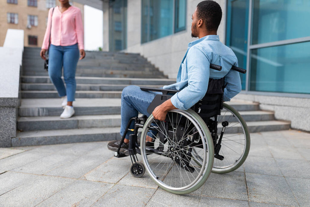 Noir handicapé souffrant de manque d'installations adaptées aux fauteuils roulants, ne peut pas entrer dans le bâtiment sans rampe - Photo, image