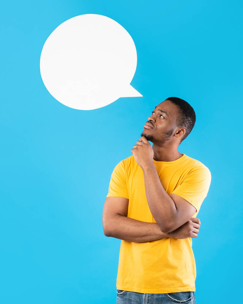 Afrikai férfi pózol beszéd buborék feje felett, kék háttér - Fotó, kép
