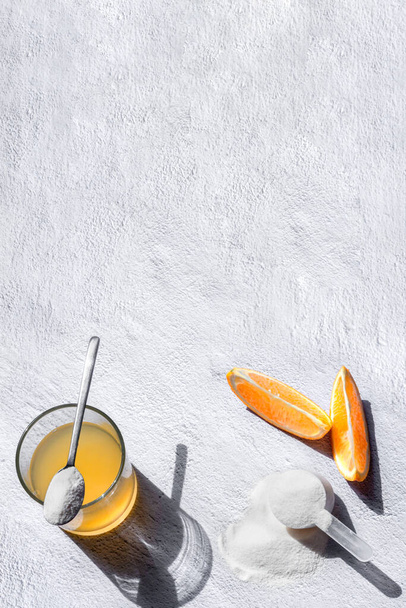 sok pomarańczowy z kolagenem łyżka pić biały szary beton tło z miejsca do kopiowania - Zdjęcie, obraz