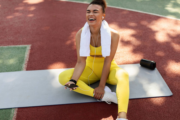 Спортивна чорна жінка в жовтому спортивному одязі слухати музику
 - Фото, зображення
