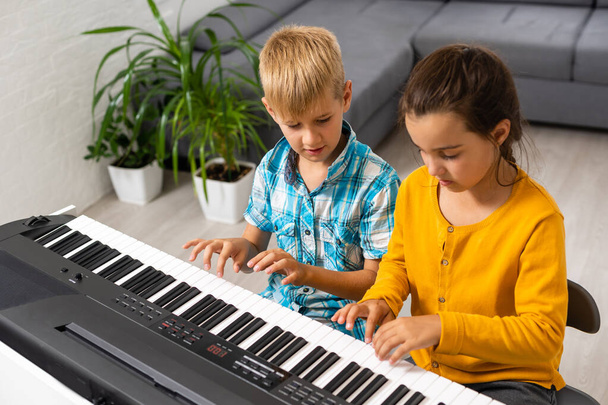 Piyano çalan çocuklar için ev müziği dersi. Karantina sırasında çocuk için evde aktivite fikri. Müzik konsepti - Fotoğraf, Görsel