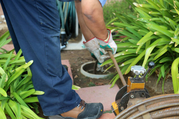 https://cdn.create.vista.com/api/media/small/498270552/stock-photo-sewer-cleaning-plumber-uses-sewer-snake-clean-blockage-sewer-line