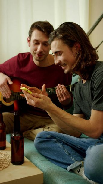 Οι φίλοι παίζουν κιθάρα και περνάνε καλά.  - Φωτογραφία, εικόνα