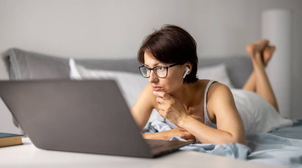 Woman using laptop in bed - Zdjęcie, obraz