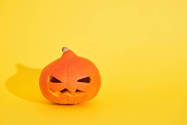 Halloween Pumpkin jack lantern from pumpkin on yellow background, copy space, halloween decoration concept - Photo, image