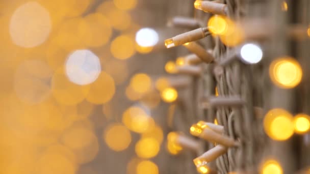 Garland Night pouliční osvětlení vánoční dekorace světla zaměřit na popředí na pozadí rozmazané bokeh zlaté barvy. Město vánoční výzdoba lampy ulici noční město. Věnec vánoční světlo provázek - Záběry, video