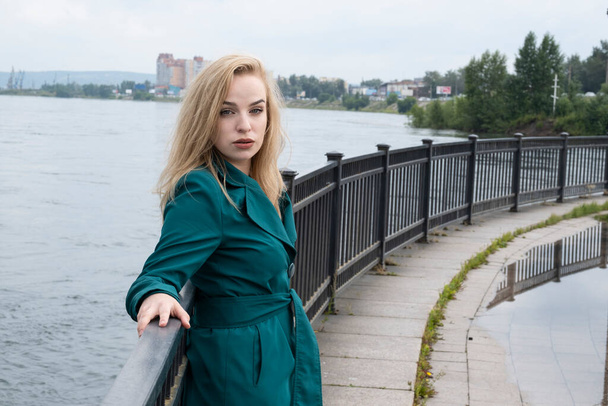 Young blonde posing at the embankment fence - Photo, Image