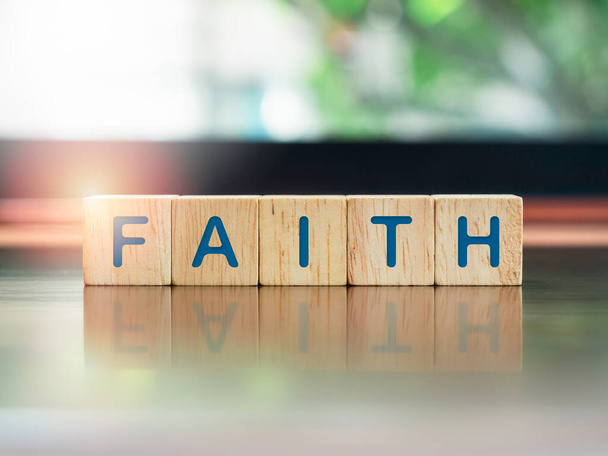 Faith, blue words on wooden cube blocks on brown wood desk and green nature background with sunlight, close up. - Fotoğraf, Görsel