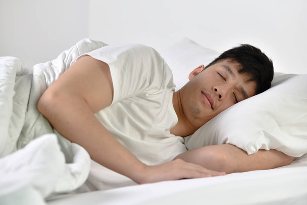 ハンサムな若いアジア人の男はベッドで寝て - 写真・画像
