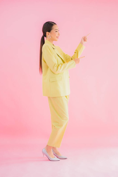 Portret mooie jonge aziatische zakenvrouw glimlach in actie op roze kleur achtergrond - Foto, afbeelding