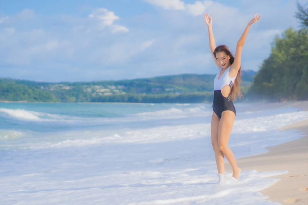 Retrato hermosa joven asiática mujer relajarse sonrisa alrededor de playa mar océano en vacaciones - Foto, Imagen