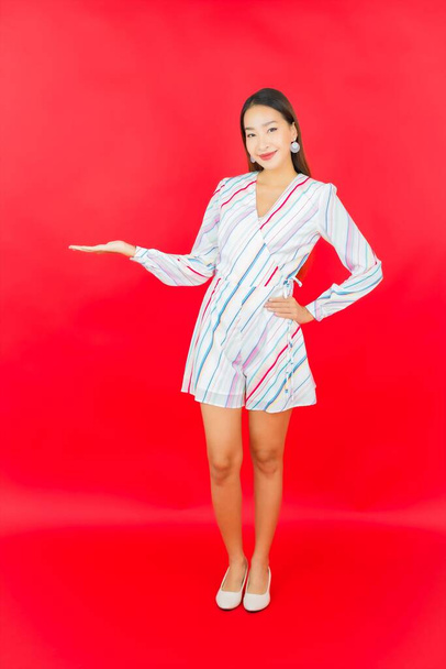 Portrait beautiful young asian woman smile with many action on red background - 写真・画像