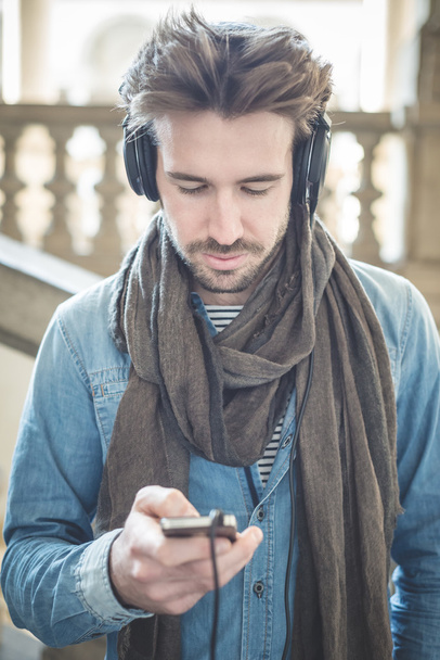 молодий красивий чоловік слухає музику з навушниками
 - Фото, зображення
