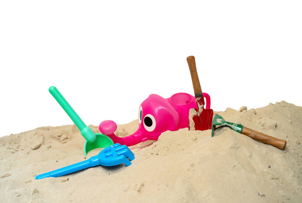 A closeup shot of beach toys on the sand isolated on a white background - Fotó, kép