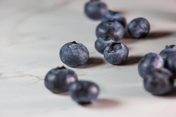 A closeup of blueberries on a white table. - Фото, зображення