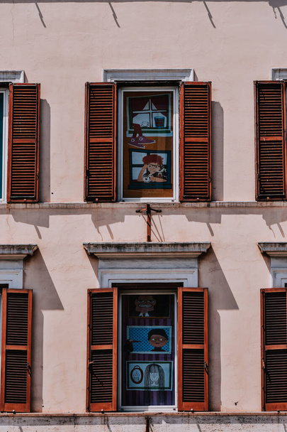 A vertical shot of windows with wooden shutters on a building in Rome - Fotoğraf, Görsel