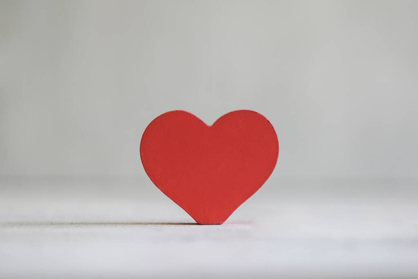Levendig rood houten liefde hart op effen witte achtergrond met kopieerruimte - Foto, afbeelding