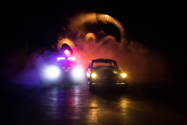 Carro da polícia perseguindo um carro à noite com fundo de nevoeiro. 911 Resposta de emergência carro da polícia acelerando para o local do crime. Foco seletivo - Foto, Imagem