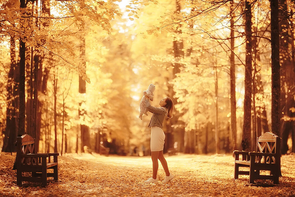 mom throws baby up autumn park, happiness yellow nature fall - Foto, imagen