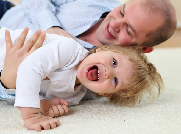 Father and son playing on the floor at home - Фото, изображение