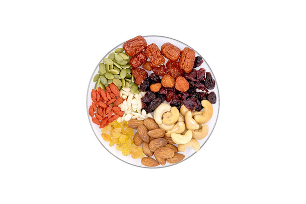 Grupo de visão superior de grãos integrais e frutas secas em uma placa de vidro isolada em fundo branco. - Foto, Imagem