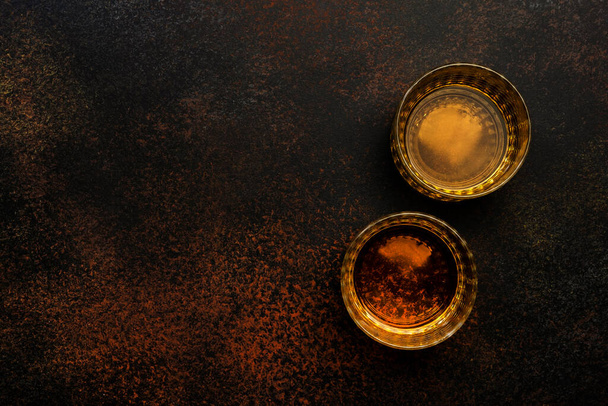 Uísque americano bourbon em copos e garrafa, fundo preto com espaço negativo - Foto, Imagem