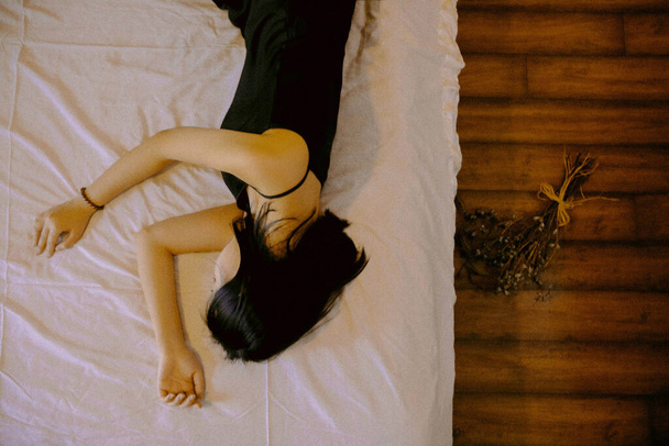 young woman lying on bed with a white cat - Fotoğraf, Görsel