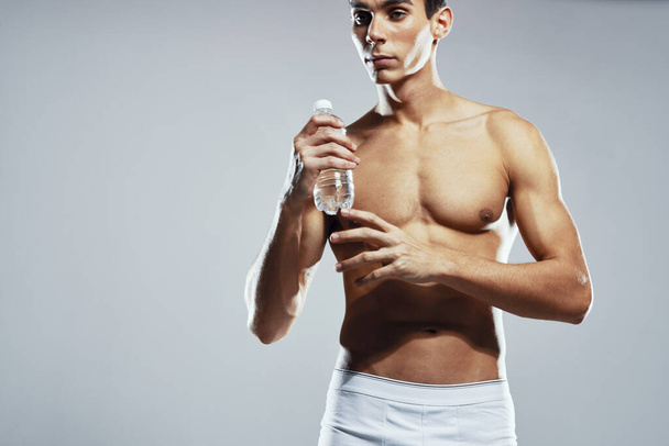 hombre deportivo en pantalones cortos blancos inflado torso posando atleta de moda - Foto, Imagen