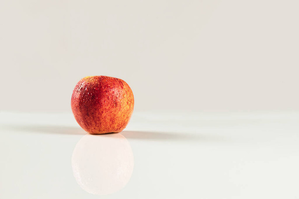 Beyaz arkaplanda damlaları olan kırmızı elmanın önplanı - Fotoğraf, Görsel