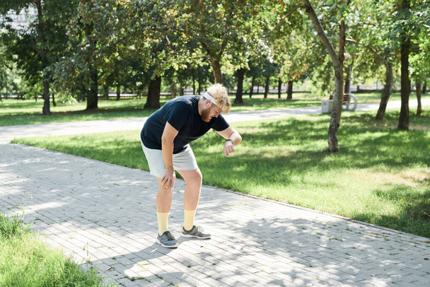 Runner utilisant le fitness tracker pendant l'entraînement - Photo, image