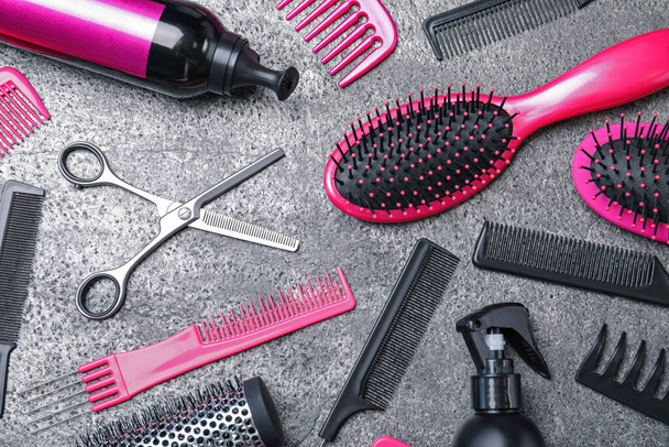 Flat lay composition of professional scissors and other hairdresser's equipment on grey table. Haircut tool - 写真・画像