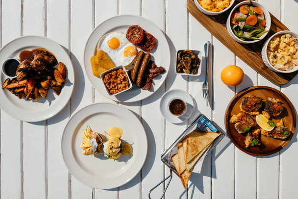 Американський сніданок закритий з бобами, ковбасами, яйцями, хеш-коричневими.  - Фото, зображення