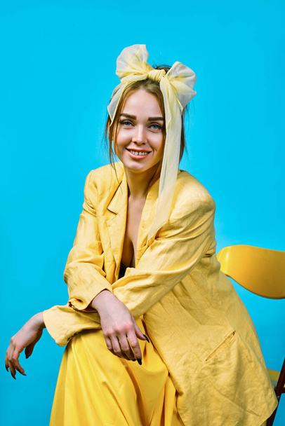portrait of  young woman in yellow jacket and headband. yellow backgroun - Foto, immagini