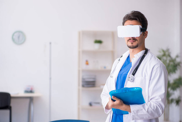Mladý lékař mužského pohlaví nosí na klinice virtuální brýle - Fotografie, Obrázek