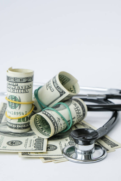 Stack of cash dollars and stethoscope. The concept of medical expensive medicine, doctors salary. Copy space for text. Health Life insurance. vaccination costs. Financial crisis. Covid-19 crimes - Fotoğraf, Görsel