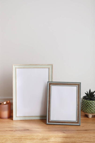 Empty photo frames and succulent on wooden table indoors - Fotoğraf, Görsel